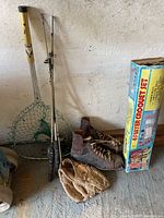 Photo showing fishing net, ball glove, vintage ice skates, part of croquet box