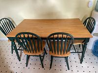 Full view of the wood dining table and four matching chairs, showing size and style.