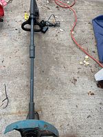Full length view of the Yardworks edger laying on concrete showing the protective blue guard at the blade.