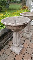 Photo showing the entire birdbath assembled outdoors on brick patio with garden background