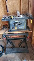 Side angle of the Mastercraft table saw mounted on Black and Decker workbench clearly showing the saw controls, blade guard, and workbench frame.