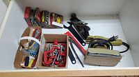 View of assorted hand tools including C-clamps, staple box, adjustable wrench, pliers, and tape measure.