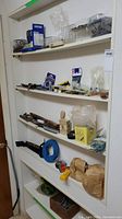 Shelf with assorted hardware boxes, plastic bags of fasteners, hand tools, and clamps.