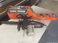 Photo showing the Craftsman 12 inch chainsaw with visible black handle and white motor casing lying on table