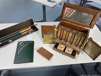 Full view of the poker set and two Budweiser pool cue handles in cases on a table.