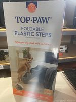 Photo of the Top Paw foldable plastic pet steps box showing an image of the steps and some product information.