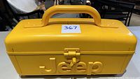 Yellow portable stereo closed showing embossed Jeep logo on front and carrying handle on top