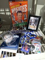 Wheaties box, framed baseball photo, autographed baseball, binder, lanyard, sticker and assorted cards on display rack