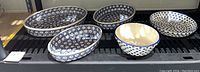 Five Polish pottery ceramic dishes and bowl arranged showing blue dot floral pattern and size variety.