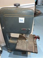 Full view of the 1950s Craftsman King Seeley band saw showing the metal frame, work table, blade slot and vise clamp.