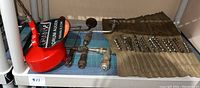 First photo shows a red hand drill, two wooden handled augers (braces), a set of metal drill bits in a rolled canvas holder, and a partially visible hand saw on the right side.