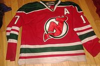 Front view of the red New Jersey Devils hockey jersey with number 17 and assistant captain 'A' patch