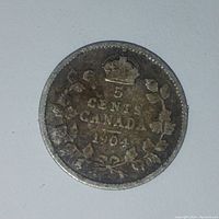Reverse side showing 5 cents denomination, Canada, year 1904, crown and maple leaves wreath.