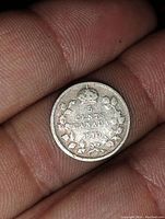 Close-up image of the 1910 Canadian 5 cent silver coin showing the reverse side with crown and maple leaf wreath, and clear date and denomination.