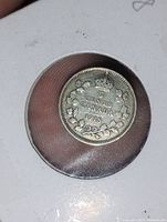 Reverse side showing denomination and date with wreath and crown.