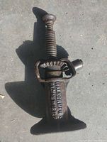 Full view of the 1924 cast iron screw jack showing overall shape, top part with threaded screw and base.