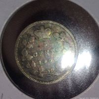 Close-up of one side of the 1900 Canadian 5 cent coin showing the denomination, crown, and wreath.