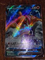 Full art holofoil Conkeldurr Pokemon card showing detailed character art, moves, HP, and holographic rainbow effect.