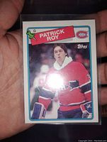 Photo of a single Patrick Roy hockey card from the 1980s in a protective sleeve, showing the front with player image in Canadiens uniform.
