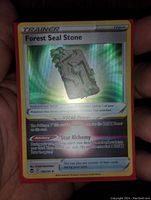 Photo of a holographic Pokémon Trainer card titled 'Forest Seal Stone' showing the full front design with holo foil effect and text details.