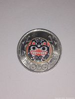Reverse side of Canadian 2 dollar coin showing colorized Hida indigenous art design.