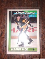 Photo of a Jaromir Jagr Super Rookie hockey card in O-Pee-Chee brand, showing the player skating with his hockey stick. Card is encased in protective plastic sleeve.