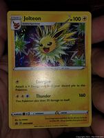 Front of Jolteon holographic Foil Pokemon card held in hand showing card details and condition.