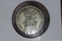 Reverse side of the coin showing a crowned lion standing on the crown of England with inscriptions indicating 'ONE SHILLING 1929' and 'FID DEF IND IMP'.