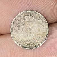 Close-up photo showing reverse side of the 1880 Canadian 5 cent silver coin with crown and wreath design, worn condition.