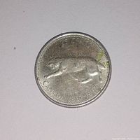 Close up of the coin displaying the bobcat design and the inscriptions '25 CENTS', 'CANADA 1867-1967'