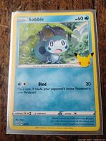 Photo of the Sobble Pokémon 25th Anniversary card showing front side with artwork, HP, attacks, and 25th Anniversary logo.