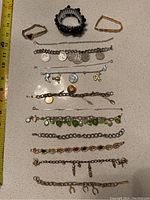 Full view of all bracelets laid out showing different designs, beads, and coin charms.