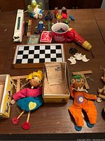 View of all items from above showing the puppets, board game, cards, and small figures spread on a table.