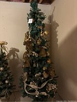 Full view of the artificial Christmas tree with assorted gold ornaments.