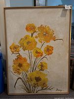 Front view of the framed floral painting with yellow and orange flowers on a textured beige background.