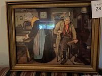 Overall view of framed print depicting elderly couple inside rustic room.