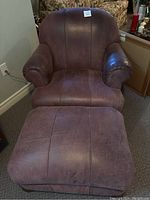 Front view of brown leather armchair with matching ottoman in front