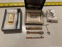 Overview of men's accessories including money clip, four tie clips, and cufflinks in box.