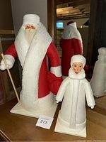 Full view of the two figures together on a table with mirror in background