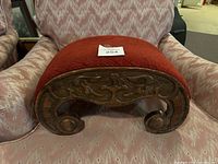 Front view of carved wood base and red upholstered top