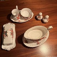 Overview of all pieces in the Royal Albert Centennial Rose 1967 service set with visible rose pattern and gold trim on white porcelain.