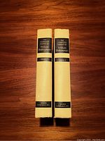 Spine view of two hardcover books titled The Complete Works of William Shakespeare, showing cream spines with black and gold labels.