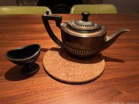 Martinoid shaped silver plated teapot and EPNS salt cellar with cobalt blue glass cup on wooden table