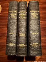 Spines of all three volumes showing titles, volume numbers, publisher imprint