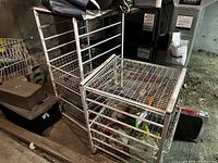 Two wire storage racks shown with three wire mesh drawers each in a basement environment.