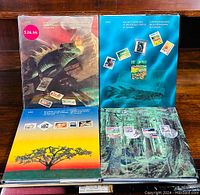 Four Canada Post souvenir postage stamp albums from 1990 to 1993 opened and displayed showing the covers and page layouts with stamps