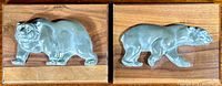 Two soapstone plaques mounted on wood, each with a carved polar bear and signed by Mod Kovie