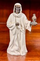 Front view of Minton The Sheik figurine showing bronze face and bird with white porcelain robe.