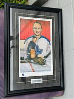 Framed color print of Johnny Bower with artist signature and hockey theme.