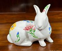 Side view of white porcelain bunny with colorful floral hand-painted pattern